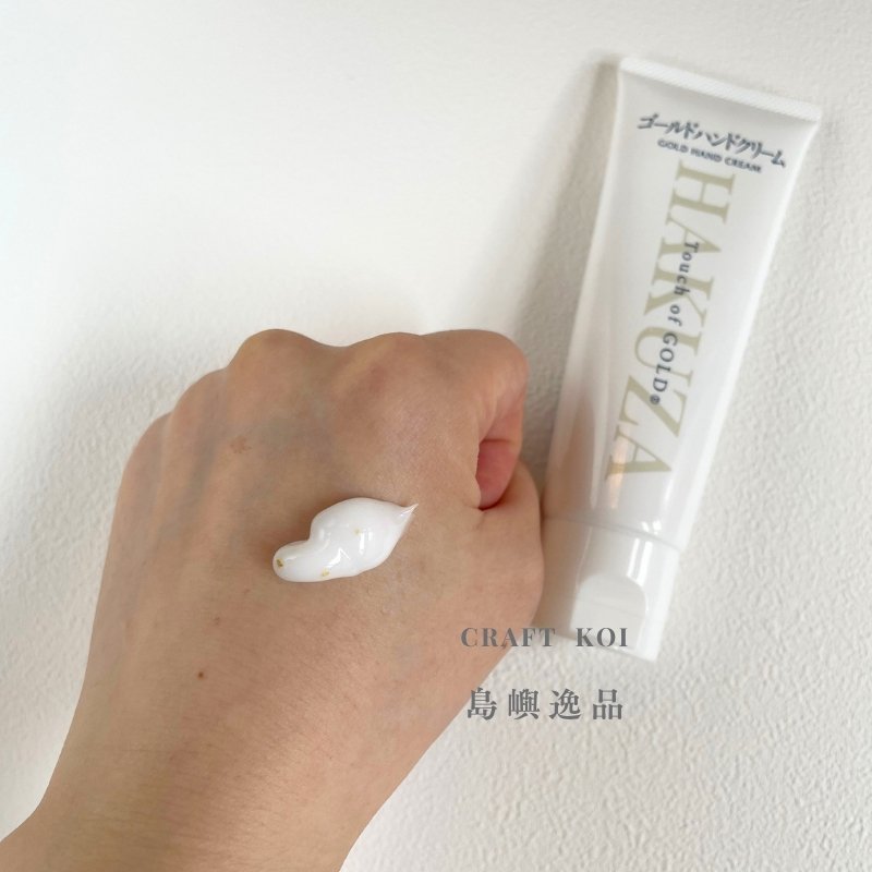 箔座 HAKUZA 金箔護手霜,擠出塗抹在手上的質地照片,有一些金箔在乳霜裡面