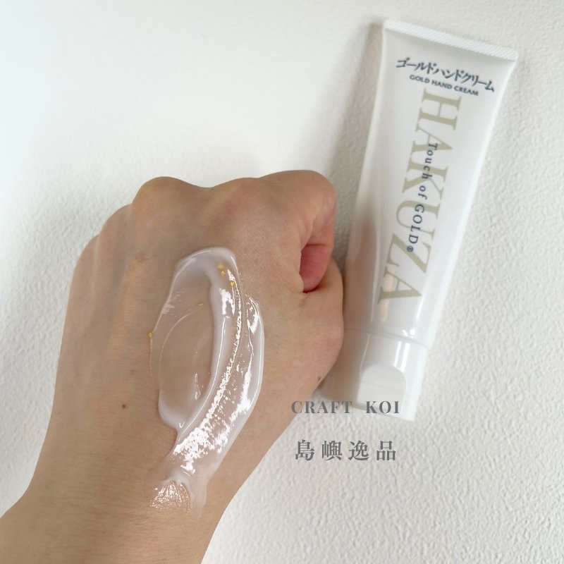 箔座 HAKUZA 金箔護手霜,擠出塗抹在手上的質地照片,有一些金箔在乳霜裡面,推開後的質地呈現照片